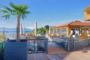 una casa con una palmera en una terraza de madera en Hotel ChiemseePanorama, en Gstadt am Chiemsee