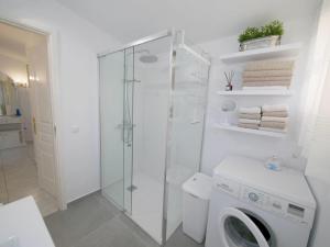 a bathroom with a washing machine and a glass shower at Chalet Sonnen-Zeit in Chayofa