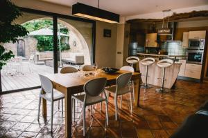 een keuken en eetkamer met een tafel en stoelen bij Provencal stone farmhouse with sea view, swimming pool and spa in Tourrettes-sur-Loup