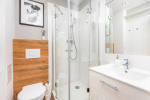 e bagno con doccia, servizi igienici e lavandino. di Apartament One by Your Freedom a Varsavia