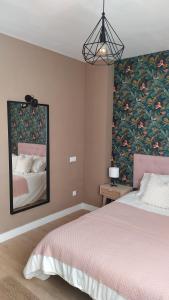 - une chambre avec un grand lit et un grand miroir dans l'établissement DIVINA GUEST HOUSE, à Manzanares