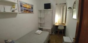 Habitación blanca pequeña con cama y escritorio en Cozy single room Mercado Central, en Alicante