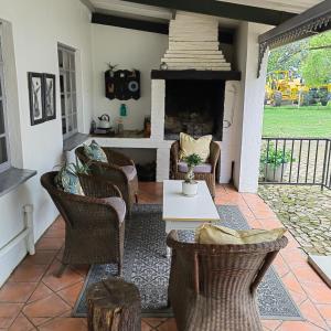 a living room with chairs and a fireplace at Rooiheuwel Cottage in Wellington