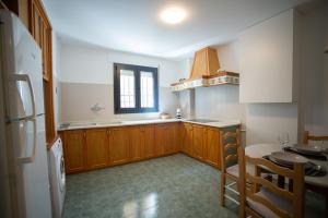 a kitchen with wooden cabinets and a table and a window at Casa Ángeles in Teruel