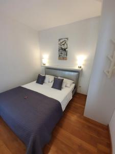 a bedroom with a large white bed with blue pillows at Apartments Marti in Murter