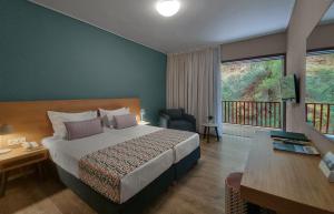 a hotel room with a bed and a balcony at Skiathos Palace Hotel in Koukounaries