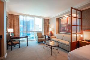 een hotelkamer met een bed, een bank en een bureau bij NO RESORT FEES-MGM StripView Adjoining Suites F1 View in Las Vegas