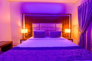 een paarse slaapkamer met een groot bed met paarse kussens bij Swat Hotel Apartments in Dammam
