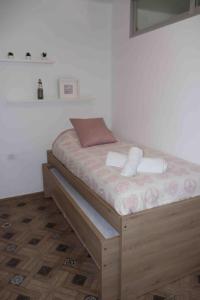 uma pequena cama num quarto com piso em madeira em Precioso apartamento con vistas al mar. Piscina. em Valência