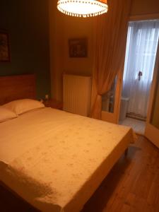 een slaapkamer met een groot bed en een kroonluchter bij Retro Central in Thessaloniki