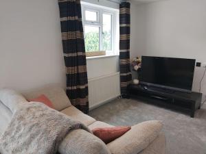 a living room with a couch and a flat screen tv at Stony Stratford Private Cosy Home in Stony Stratford