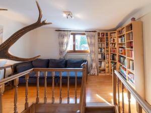 een woonkamer met een blauwe bank en boekenplanken bij Les Lits de la Semois in Bouillon