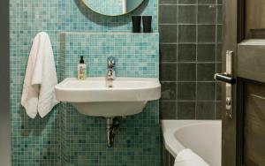 baño de azulejos azules con lavabo y bañera en Perfect Studio Home downtown Berlin, en Berlín