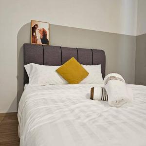 sypialnia z białym łóżkiem i żółtą poduszką w obiekcie Home at Indera Mahkota Kuantan Unifi 100mb+ TV BOX w mieście Kuantan
