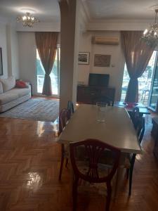 een eettafel en stoelen in de woonkamer bij Retro Central in Thessaloniki