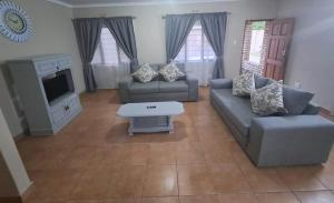 a living room with two couches and a tv at M&M Self Catering in Richards Bay