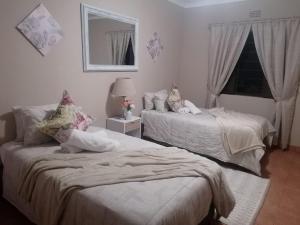 a bedroom with two beds and a mirror at M&M Self Catering in Richards Bay