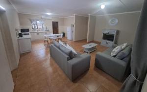 sala de estar con 2 sofás y cocina en M&M Self Catering en Richards Bay