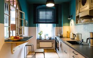 una cocina con paredes verdes y una barra con taburetes en One Bedroom Apartment with Balcony H12, en Berlín