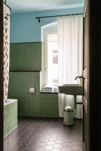 baño verde con lavabo y ventana en One Bedroom Apartment with Balcony H12 en Berlín