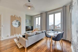 ein Wohnzimmer mit einem Sofa und einem Tisch in der Unterkunft Cosy Jungle Un magnifique F5 in Rouen