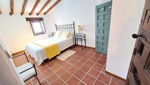1 dormitorio con 1 cama y suelo de baldosa en Casa Rural Casasola en Chinchón