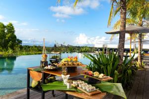 a buffet of food on a table next to a pool at MAUA Nusa Penida Bali in Nusa Penida