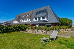 a house with two lawn chairs in front of it at App Kampen in Kampen