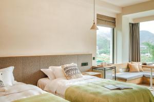 ein Hotelzimmer mit 2 Betten und einem Sofa in der Unterkunft Creek Moganshan Design B&B in Deqing