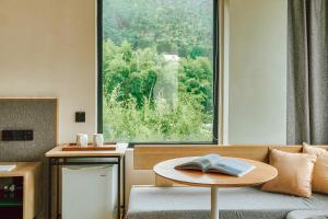 ein Wohnzimmer mit einem Tisch und einem Buch darauf in der Unterkunft Creek Moganshan Design B&B in Deqing