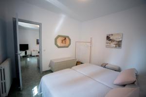 een witte slaapkamer met een bed en een spiegel bij Casa Ángeles in Teruel