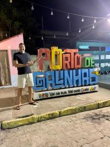 a man standing in front of a sign that reads carghai at Porto de Galinhas - Flat 6 - Residencial Lagoa de Porto in Porto De Galinhas