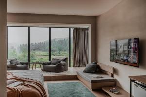 1 dormitorio con cama y ventana grande en Creek Moganshan Design B&B en Deqing