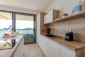 a kitchen with white cabinets and a view of the ocean at Sunset Apartments in Blato