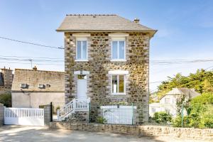 a stone house with a white fence in front of it at Le Crayon - A 200m de la plage in Pléneuf-Val-André
