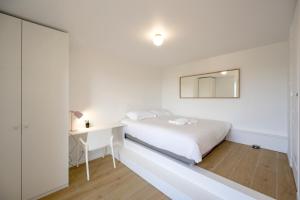 a bedroom with a bed and a desk and a mirror at Le Crayon - A 200m de la plage in Pléneuf-Val-André
