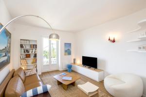 a living room with a couch and a tv at Le Crayon - A 200m de la plage in Pléneuf-Val-André