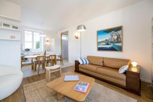 a living room with a couch and a table at Le Crayon - A 200m de la plage in Pléneuf-Val-André