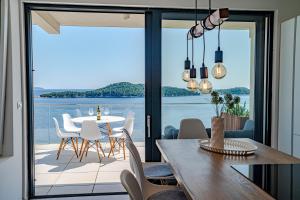 a dining room with a view of the ocean at Sunset Apartments in Blato
