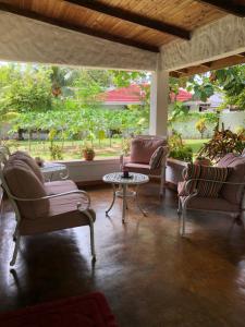 a living room with two chairs and a table at HCS Bungalows Turtle Bay Rustic Bungalow in Au Cap