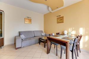 sala de estar con sofá y mesa de comedor en Patio Mare - Garden by Grand Apartments en Sopot