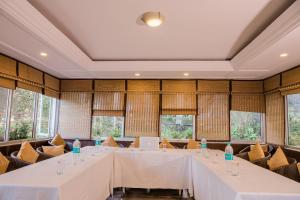 a long table in a room with windows at Hotel Shiva Continental in Mussoorie