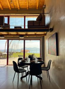mesa y sillas en una habitación con ventana grande en Modern Stone Villas with Swimming Pool en Aliveri