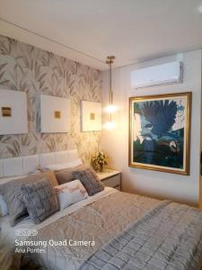um quarto com uma cama e um quadro na parede em Studio charmoso muito bem localizado em São Paulo