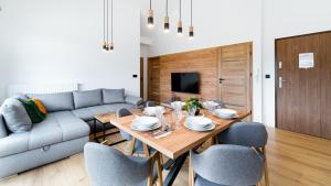 a dining room with a table and chairs and a couch at Hillside, Sun & Snow in Karpacz