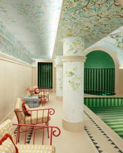 Cette chambre dispose d'un plafond peint avec une colonne et des chaises. dans l'établissement Le Grand Mazarin, à Paris