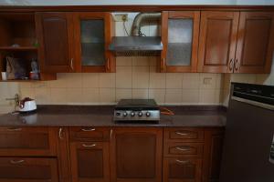 a kitchen with wooden cabinets and a stove top oven at DESIRE Service Apartments- CyberCity in Gurgaon