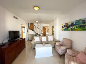 a living room with a couch and a tv at Penthouse by the beach in Torrox Costa