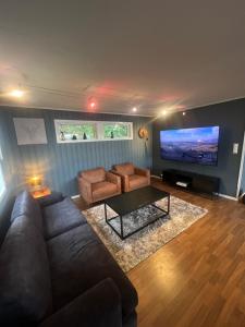 sala de estar con sofá y TV de pantalla plana en All inclusive villa, en Lillehammer