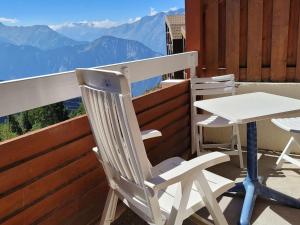 Biały stół i krzesła na balkonie z widokiem na góry w obiekcie Duplex 6 pers, skis aux pieds, piscine & sauna - L'Alpe d'Huez - FR-1-405-211 w mieście LʼHuez +3 zdjęcia